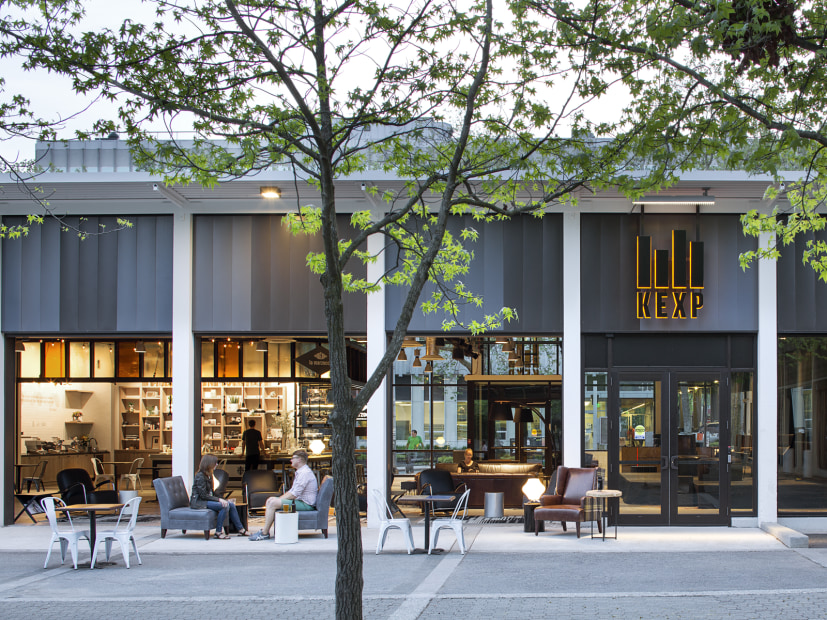 People sit outside of La Marzocco Café and the KEXP gathering space in downtown Seattle near the Space Needle, picture