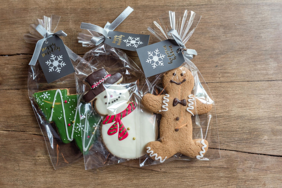 Homemade gingerbread cookies decorated and put in cellophane bags with ribbons to give as gifts, image