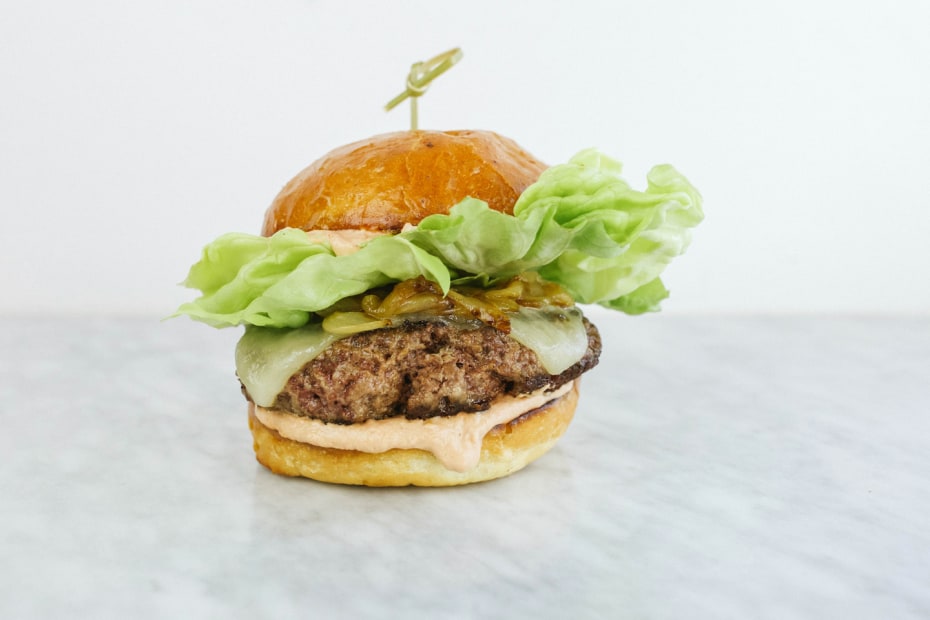 burger with bibb lettuce, grilled onions, melted cheese in bun at Belcampo Restaurant and Butcher Shop in Oakland, California, picture 