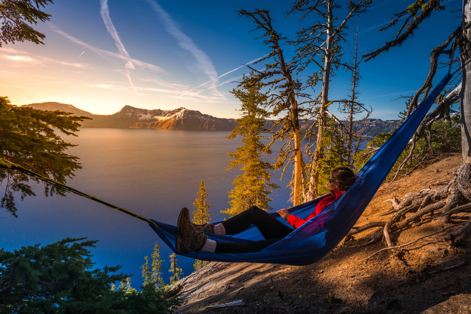 A woman lounges in a hammock overlooking Crater Lake in Crater Lake National Park in Oregon, picture