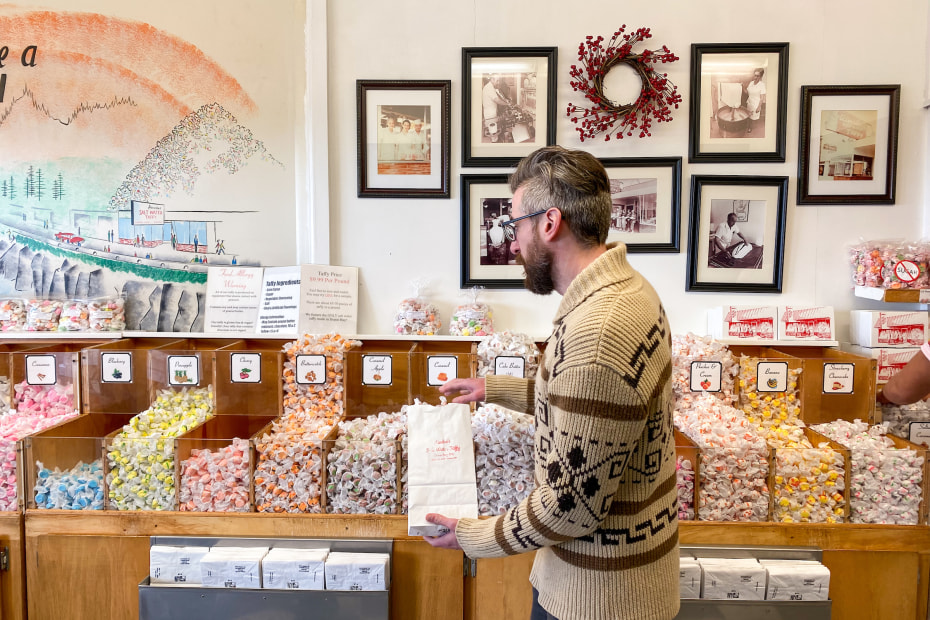 a customer puts a variety of taffy into a bag at Ainslee's Homemade Saltwater Taffy