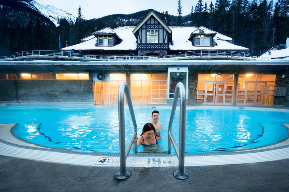 couple enjoying the warm mineral waters of open-air pool in Banff, Alberta, picture