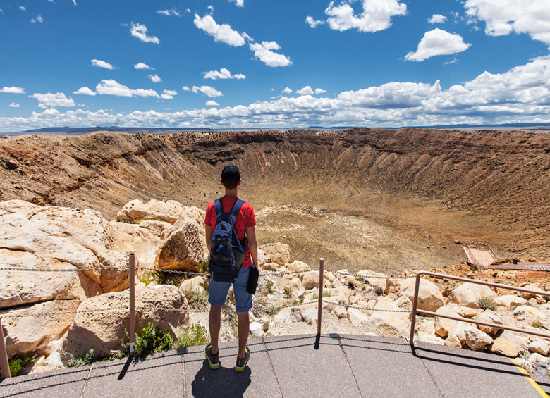 a hiker looks over a meteor crater, just outside Winslow, Arizona, picture