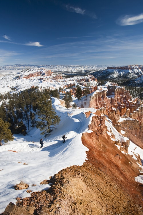 Two snowshoers hike along Bryce Amphitheater in Bryce Canyon's National Park, picture