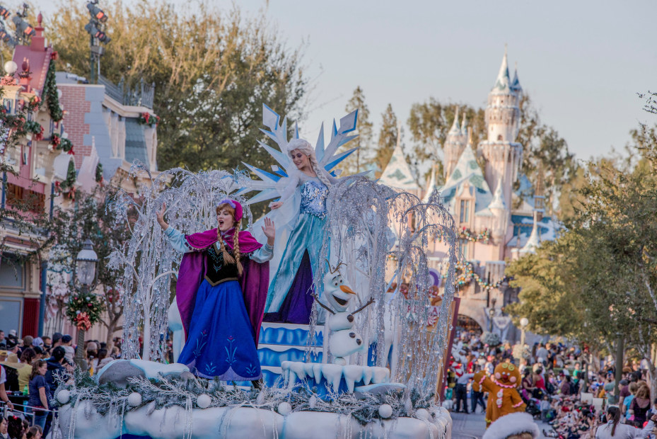 Elsa and Anna from Frozen sing and dance on a float in Disneyland's “A Christmas Fantasy” daily parade.