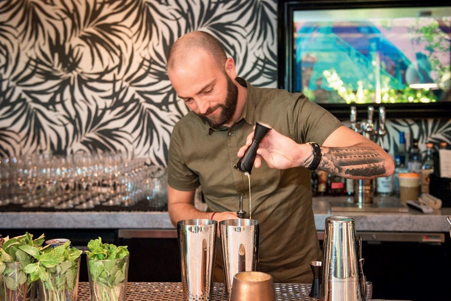 Across the Pond co-owner Joshua James mixes a drink, picture