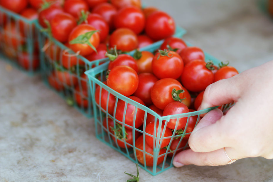 baskets of bright red cherry tomatoes at the farmers market, picture