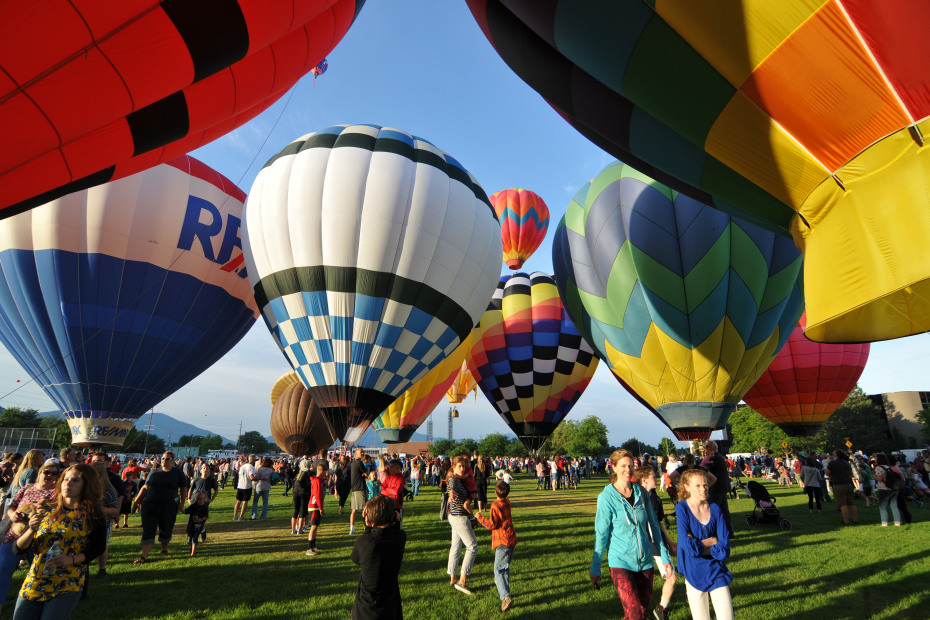 Visitors in a field surrounded by hot-air balloons in Provo, Utah, photo