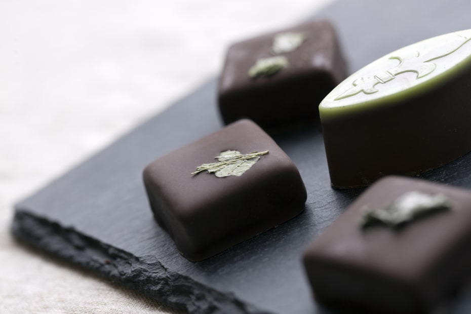 three squares of chocolates and an oval from a slate platter