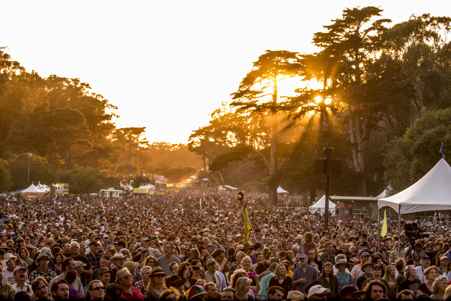 A crowd of people attend Hardly Strictly Bluegrass at sunset in San Francisco, photo