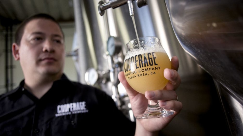 Brewer pours an ale at Cooperage Brewing Company, photo