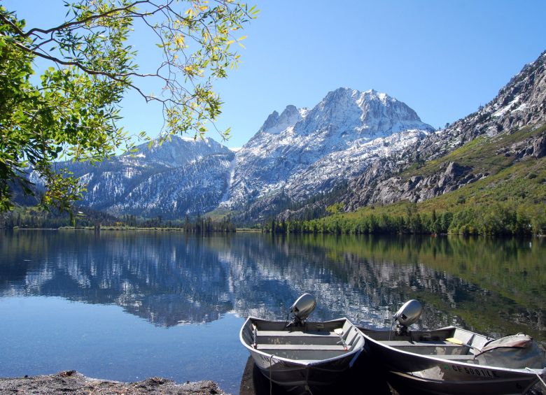 Motorboats docked at Silver Lake in California with mountains in the background, photo