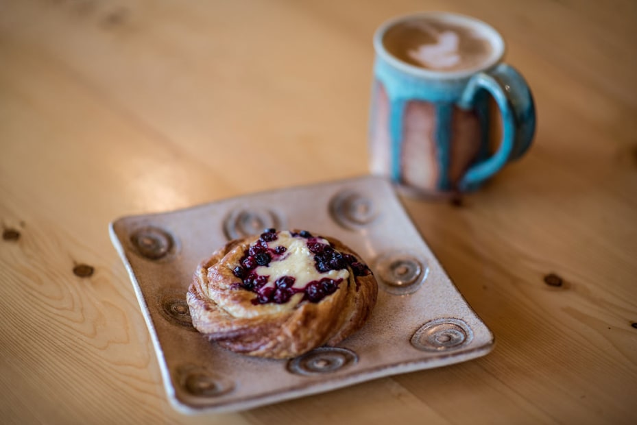 photo of a mug of coffee and a fruit danish on a table