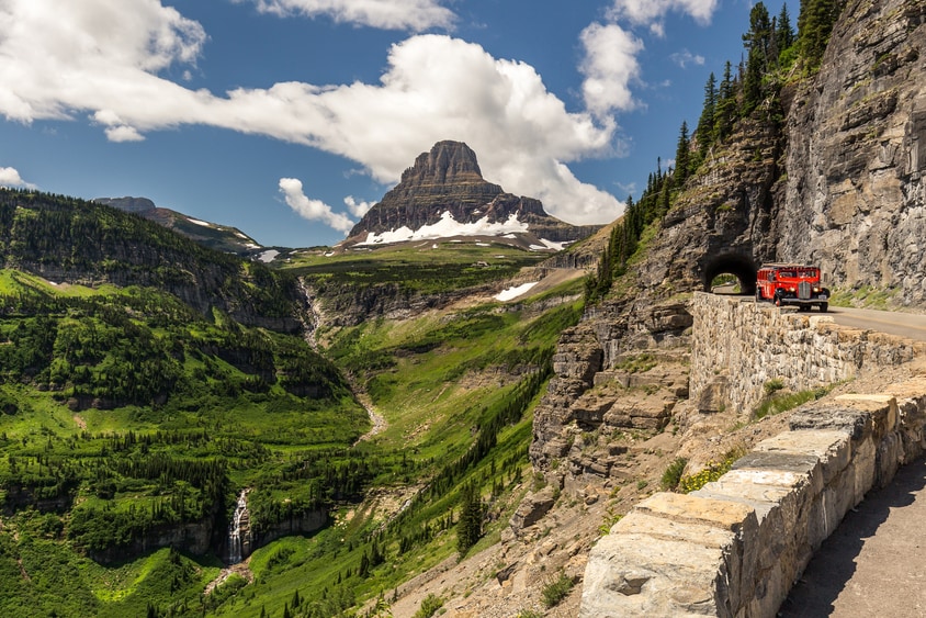 Famous red National Park Service vehicle drives tourists around Glacier National Park, image