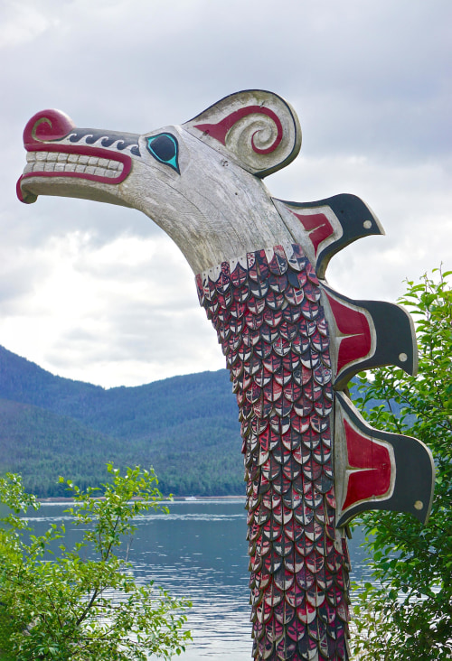 a totem at the edge of a lake, picture