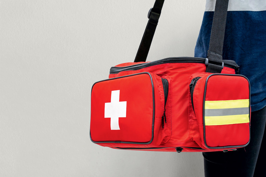 Photo of a person carrying a red first-aid duffel bag