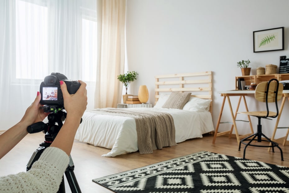 A woman takes a home inventory photo of her bedroom.