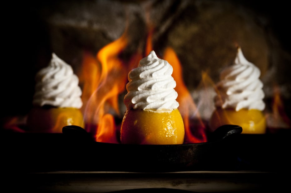 Flaming Orange desserts with flames in the background from the Chico Hot Springs historic Dining Room