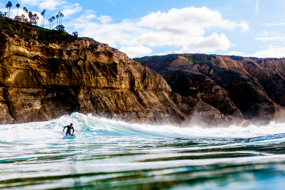 With cliffs towering over him, a surfer pulls out of a wave in San Diego, California. picture