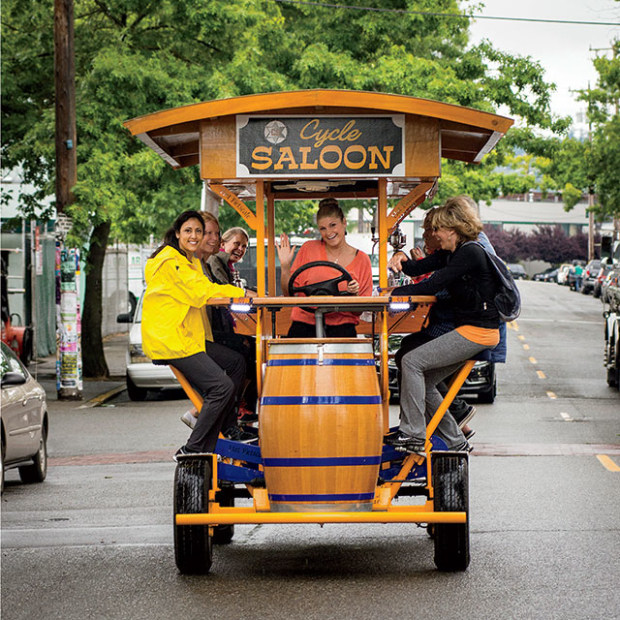 people ride on the pedal-powered Cycle Saloon, picture