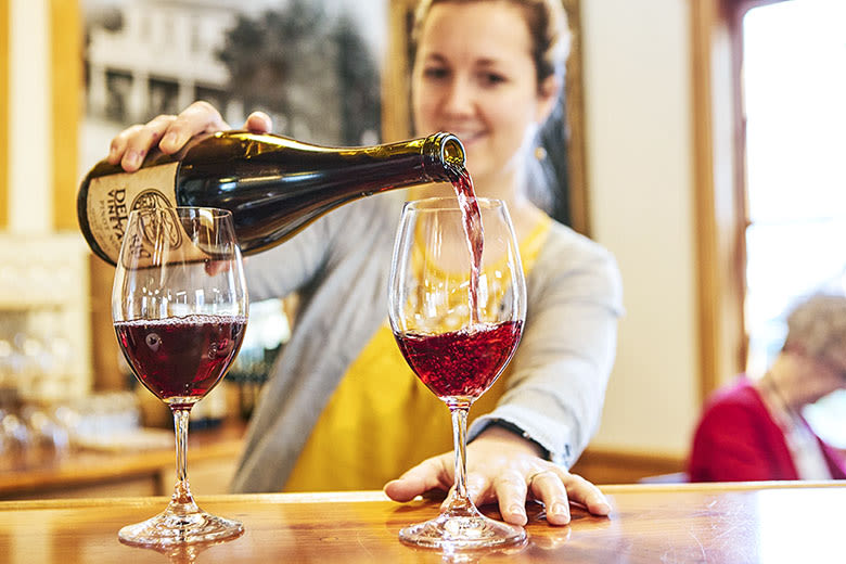 woman pours a glass of red wine at Del Rio Winery in Gold HIll, Oregon, picture