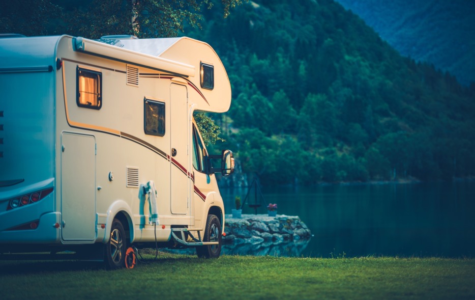 picture of an RV parked near a lake at twilight