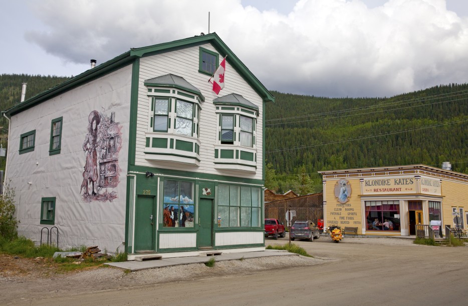 picture of the Dawson City, Yukon, with mountains and clouds in the background