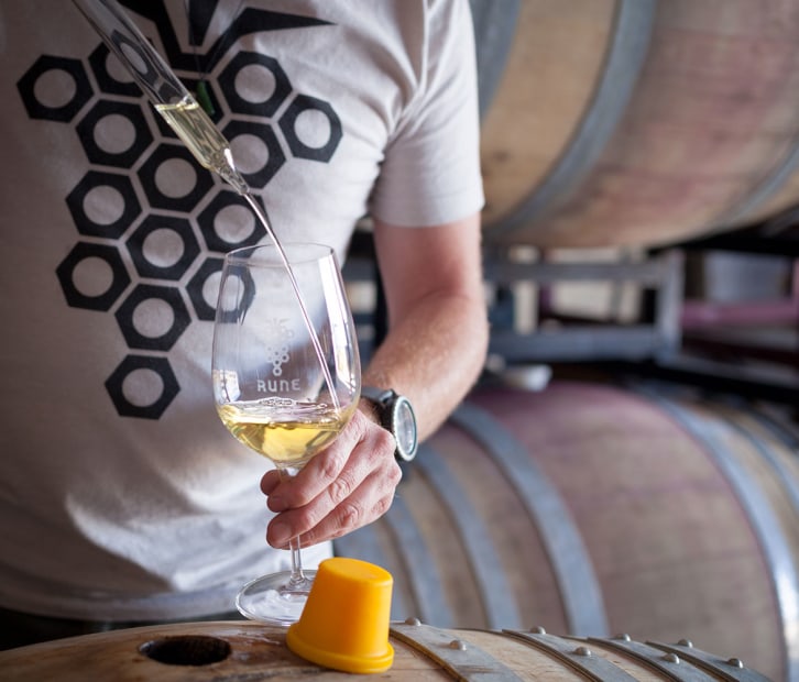 Rune Vineyards' James Callahan pours a barrel sample of white wine into stemmed glass in Sonoita, Arizona, picture