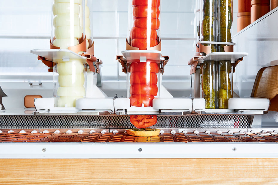 Creator's burger machine slices toppings of onion, tomato, and pickle in San Francisco, picture