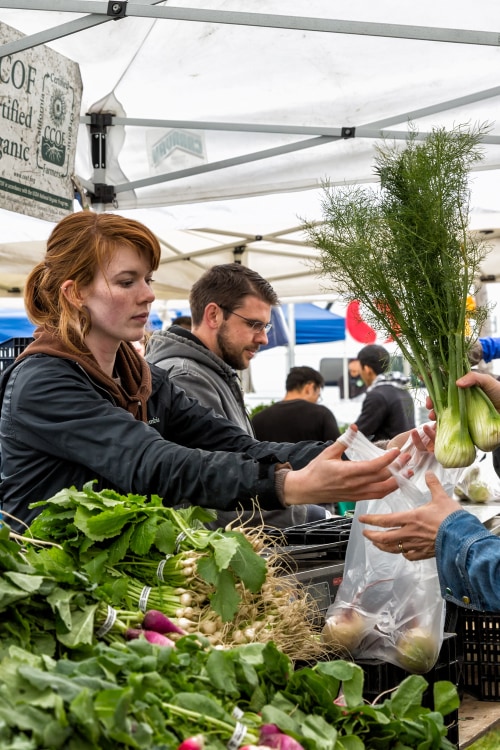 A vendor bags fennel at the Grand Lake-Oakland Farmers Market, image