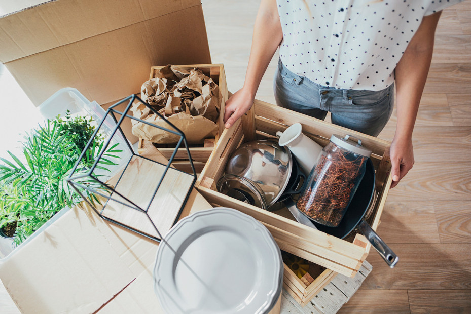 woman holding open box of miscellaneous kitchen items, picture