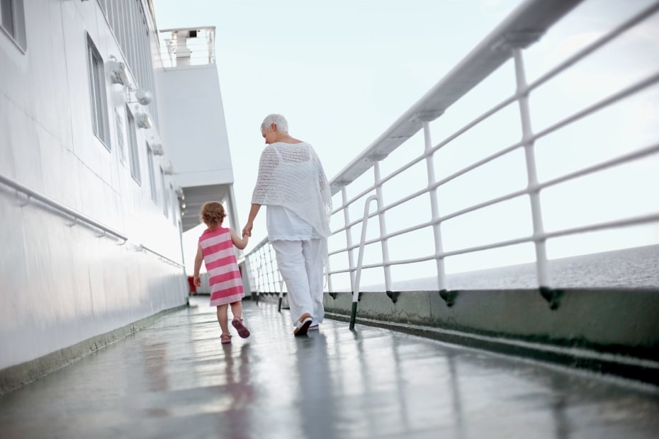 Grandmother and granddaughter hold hands as they share a stroll on deck