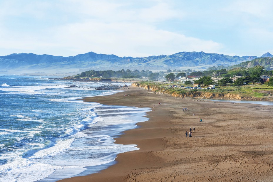 Moonstone Beach panorama with strollers on sunny afternoon in Cambria, California