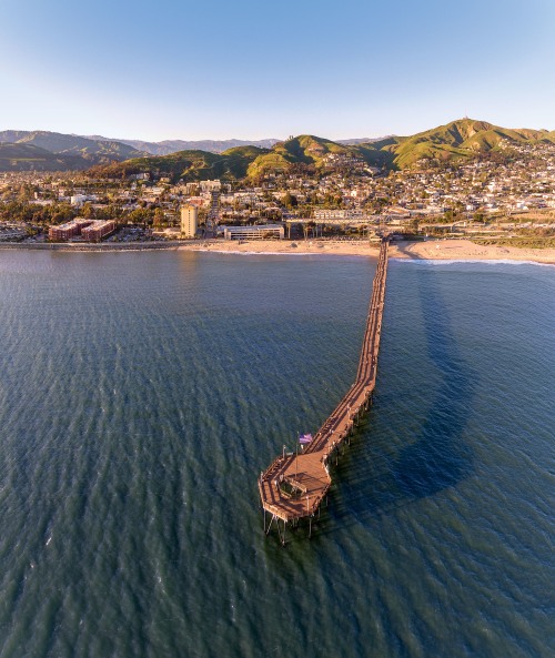 Ventura Pier from above as it juts into the Pacific with mountains in background in Ventura, California