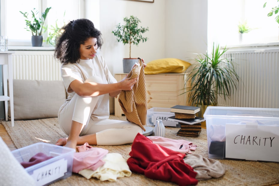 A woman goes through her clothes to donate items to charity.