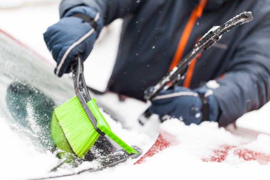 AAA Member removes ice and snow from windshield.