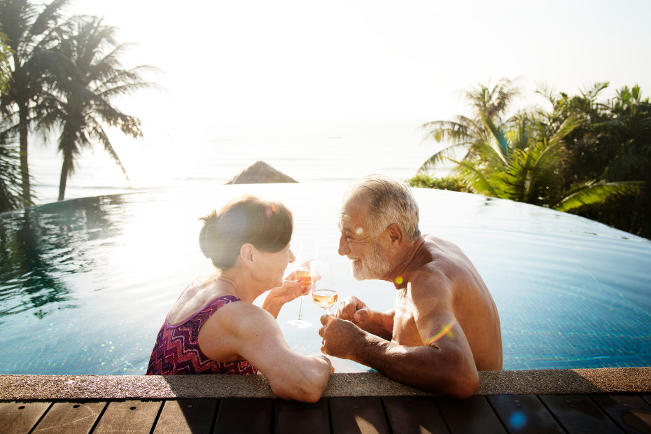 AAA Members sip on drinks in a pool at an all-inclusive resort in the tropics.