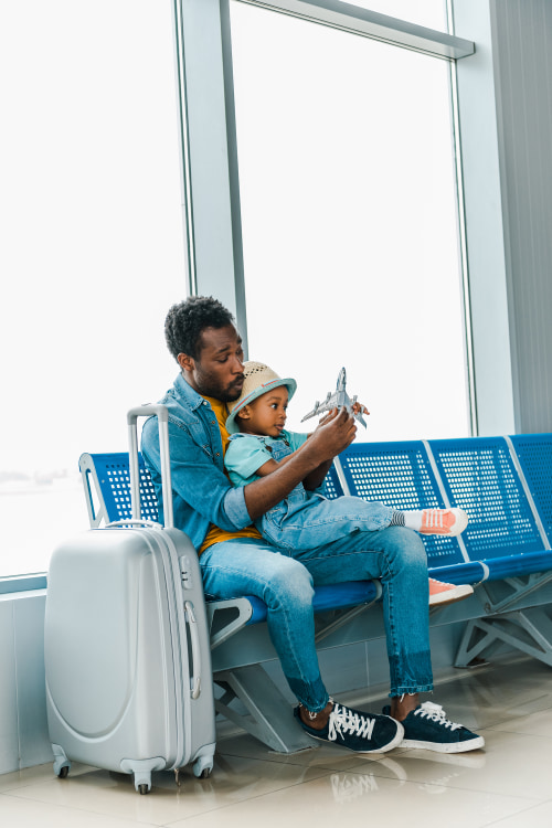 AAA Member plays with his son at the gate in an airport.