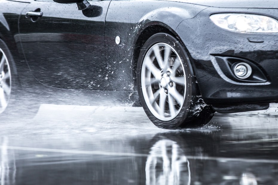 AAA insured car drives through a puddle on the road.