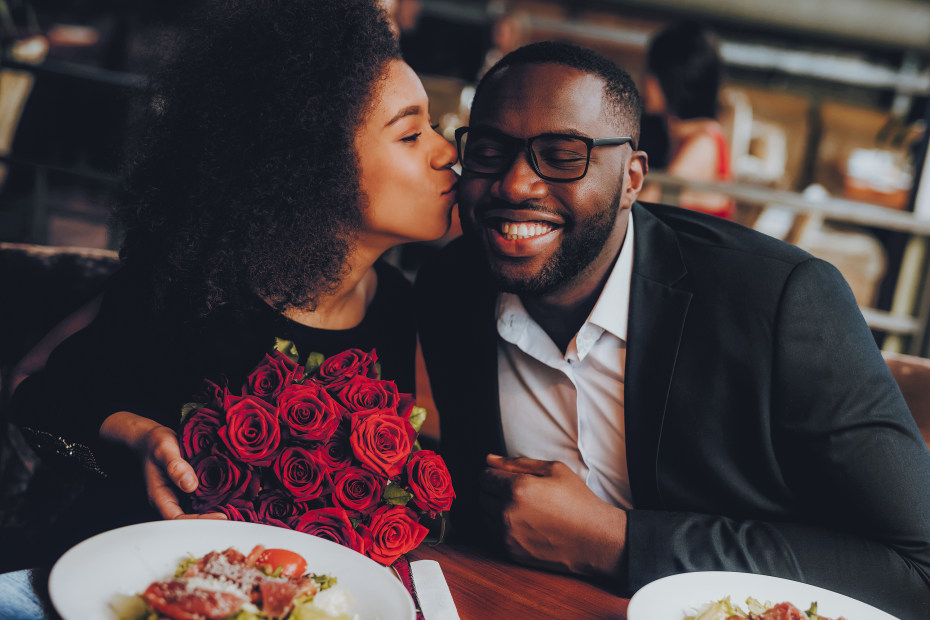 Couple enjoying a Valentine's Day dinner with flowers.