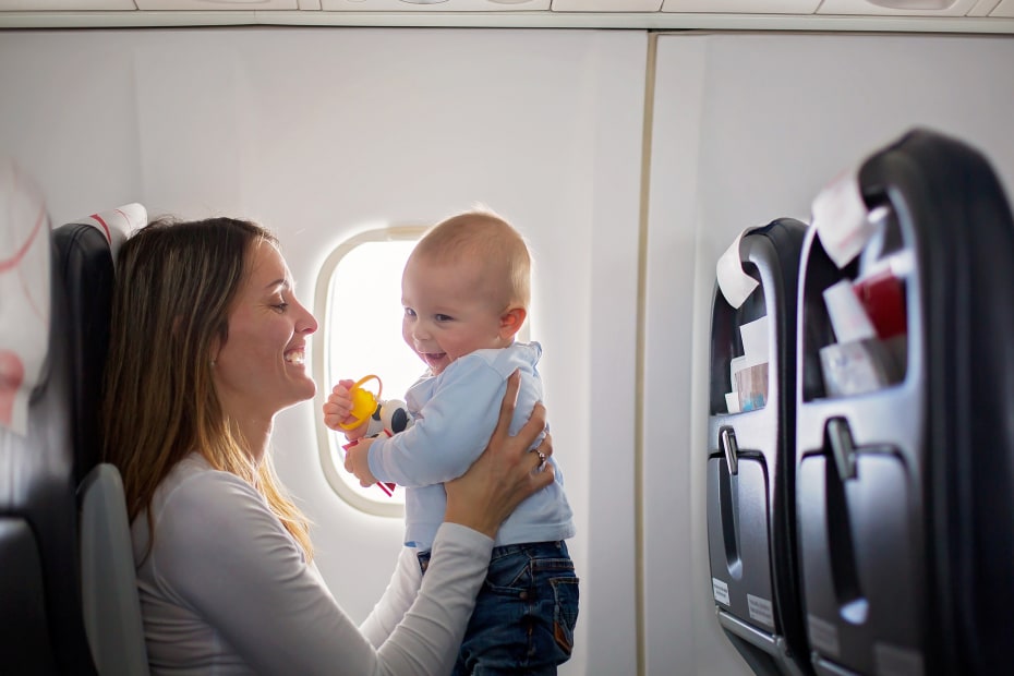 Baby and mom playing together on an airplane.