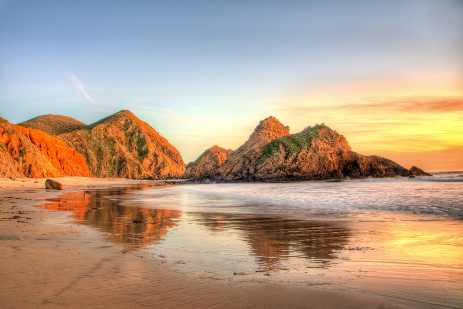 The rocks at Pfeiffer Beach in Big Sur, California, lit up by golden light at sunset.