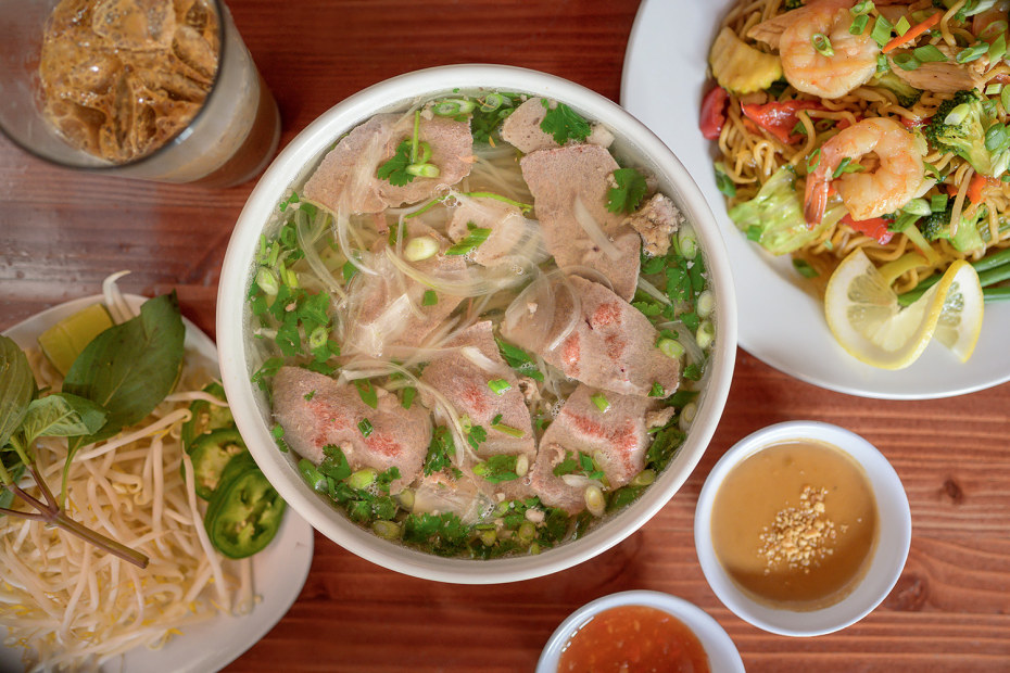 bowl of beef pho and plate of Cambodian street noodles viewed from above at Moe Pho in Pendleton, Oregon, image