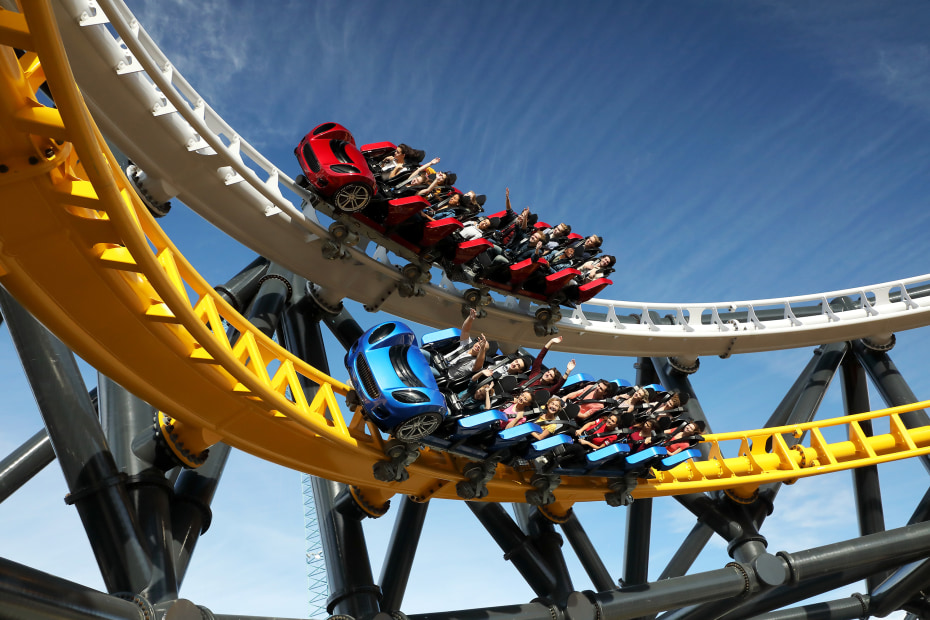 Photo of people riding a roller coaster with twin tracks. 
