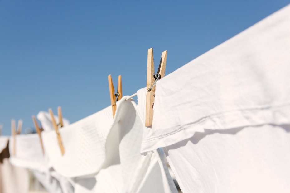 clothesline with white sheets held by wooden clothespins