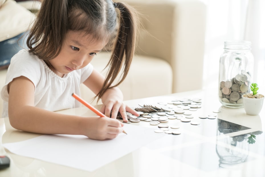 A young girl adds up her money.