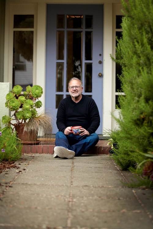 Peter Fish seated on front steps of his home
