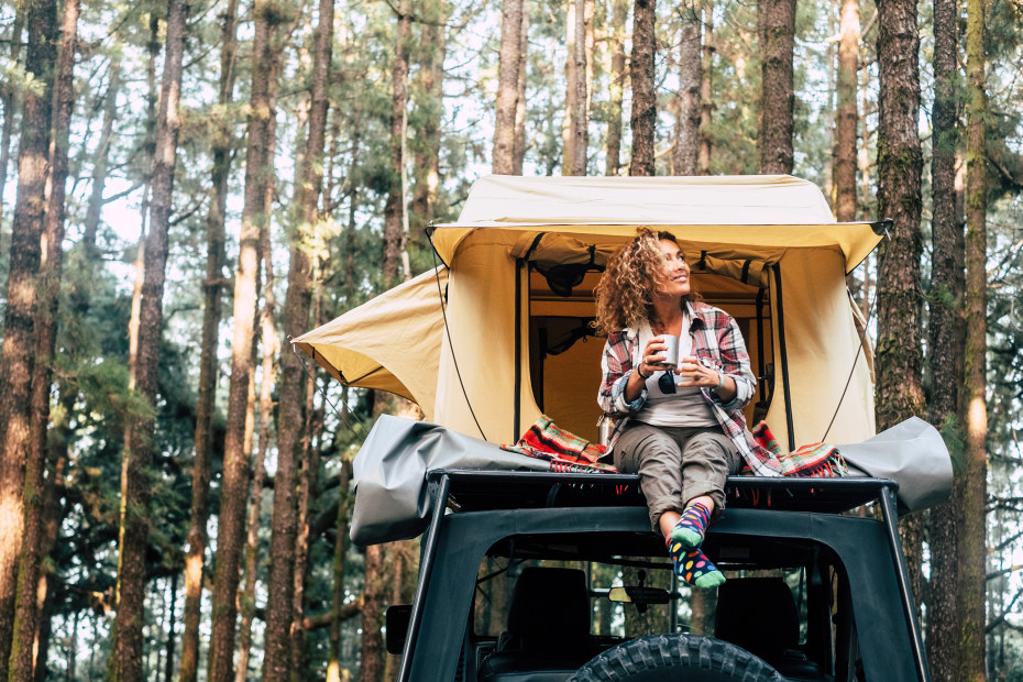 AAA Member sits in a rooftop tent taking in the view.