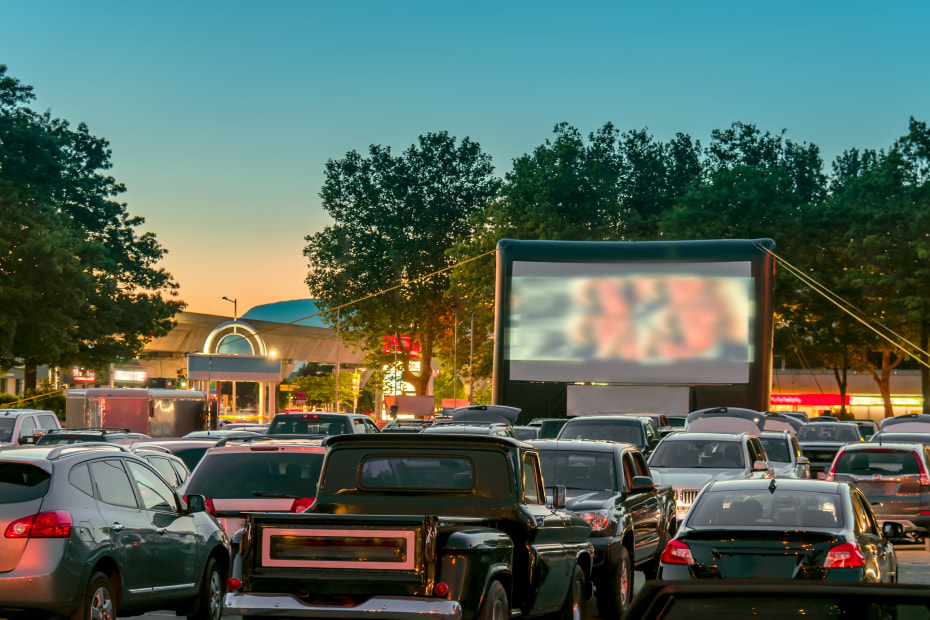 Cars in front of the screen at a drive-in theater.