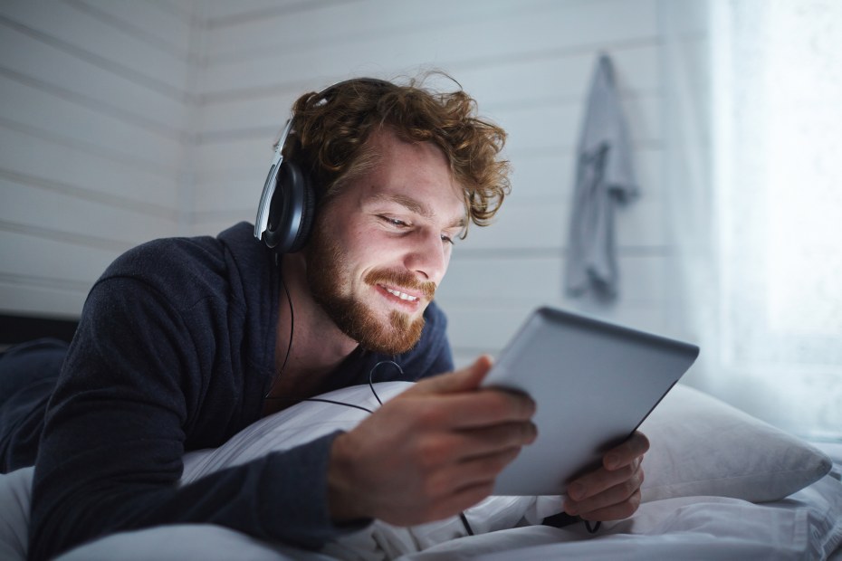 A man watches a movie on a tablet.